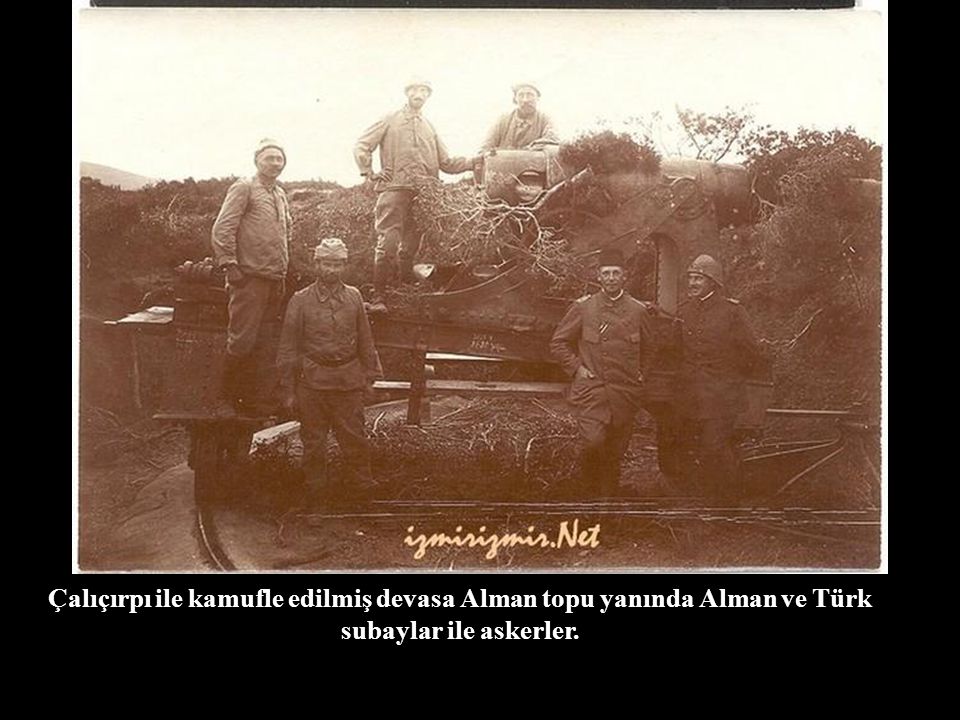 Çalıçırpı ile kamufle edilmiş devasa Alman topu yanında Alman ve Türk subaylar ile askerler.