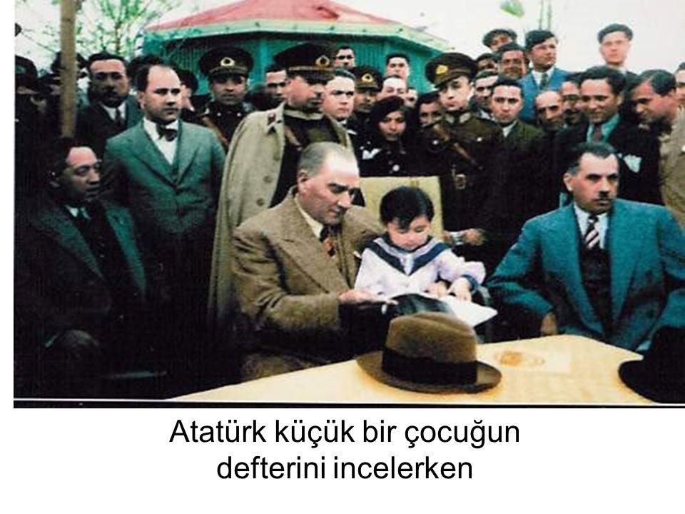 Atatürk küçük bir çocuğun defterini incelerken